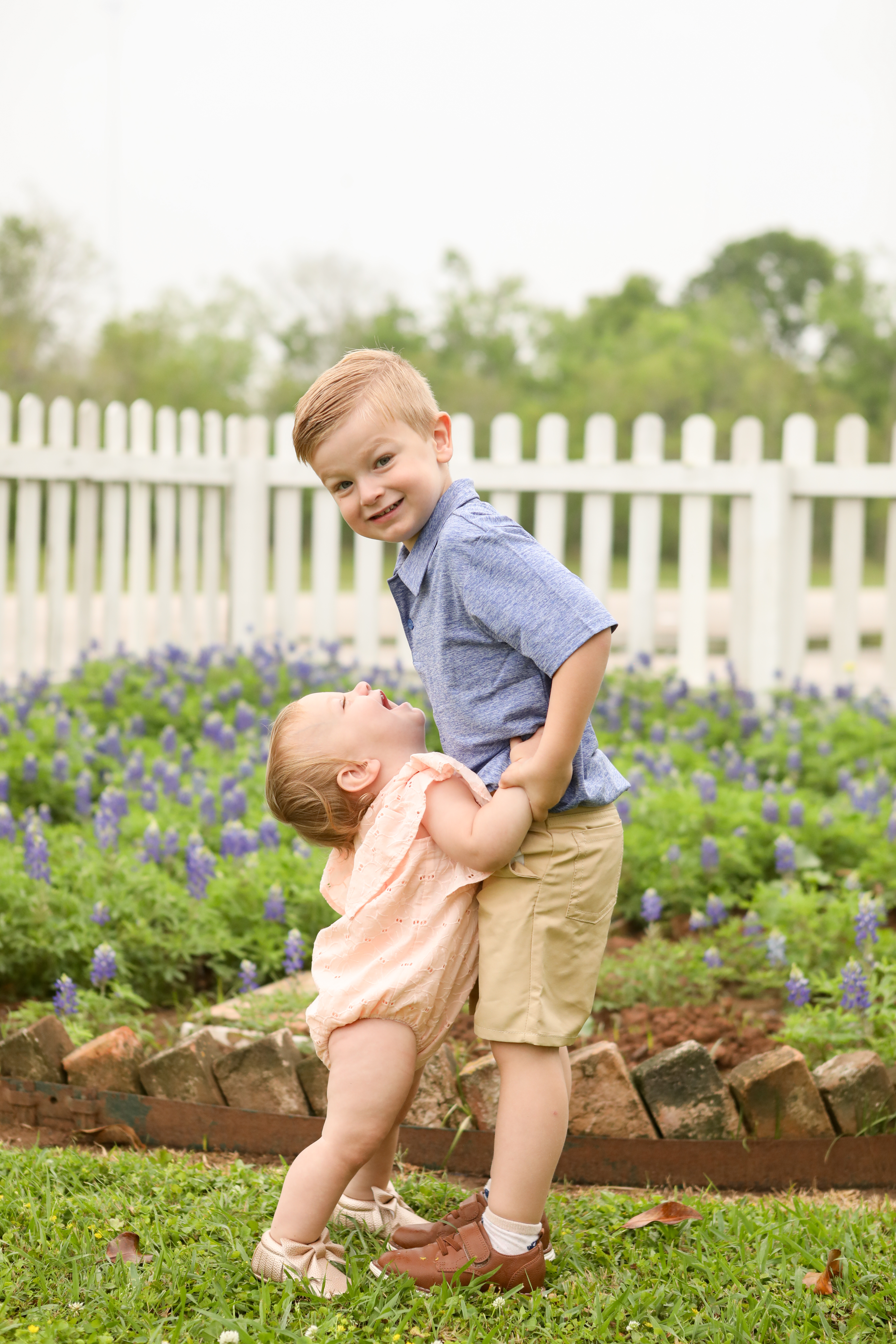young brother and sister take pictures with the bluebonnets in missouri city texas